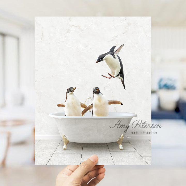 a hand holding a card with three penguins in a bathtub