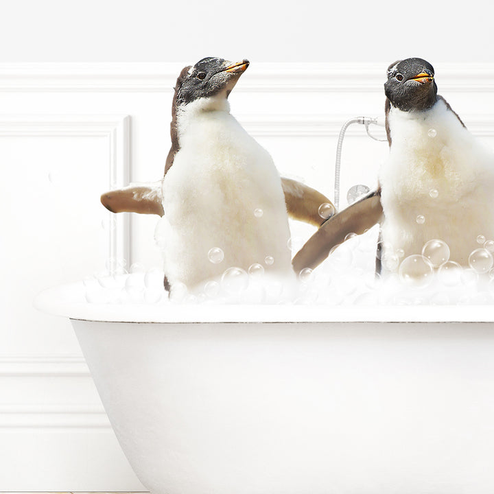 two penguins sitting in a bathtub with bubbles