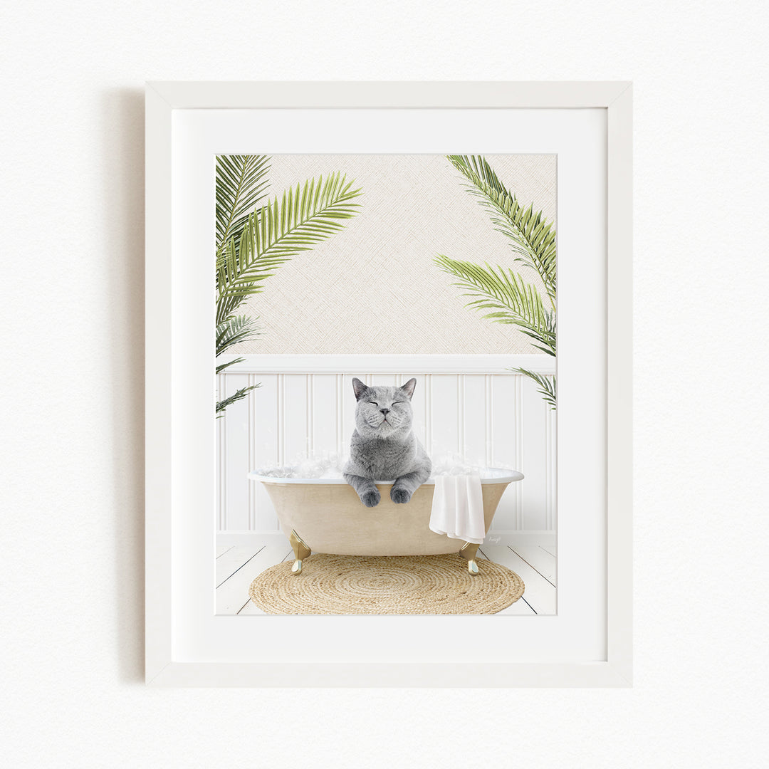 A gray cat sitting in a white bathtub, surrounded by green palm leaves, creating a serene and relaxing atmosphere.