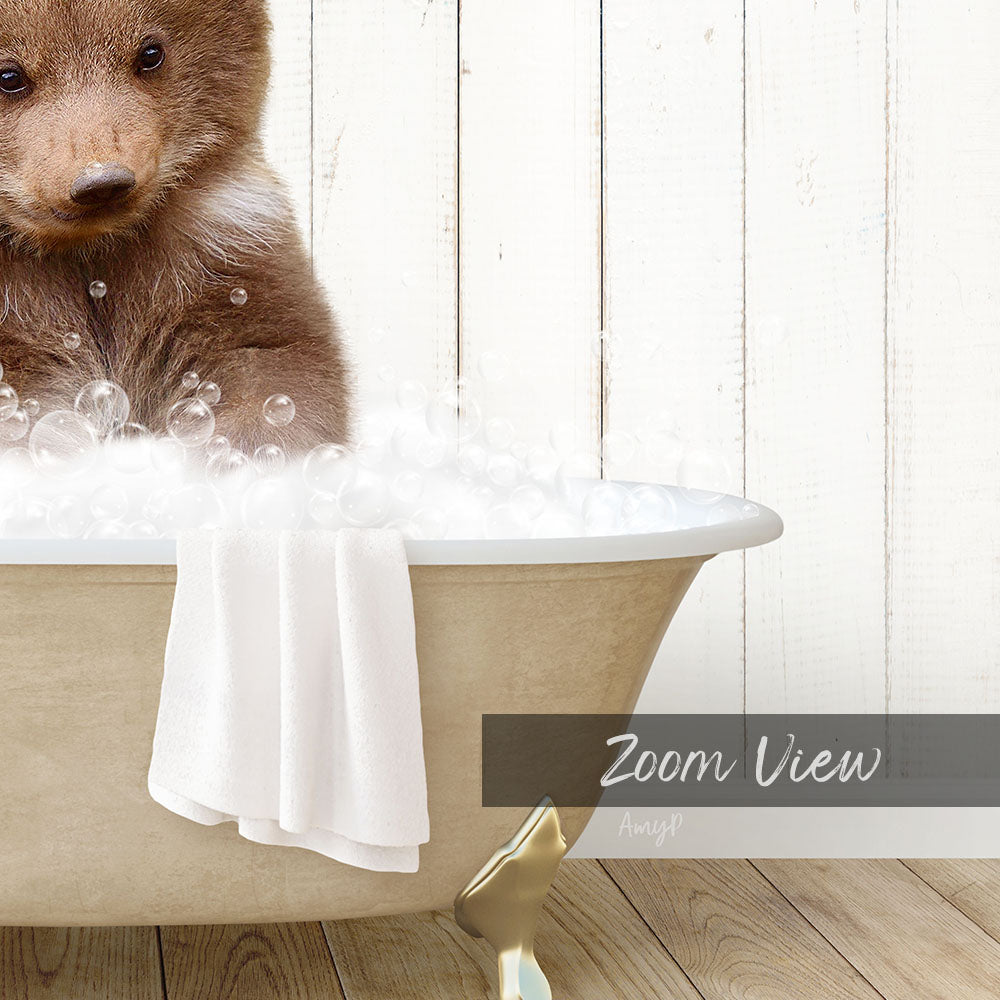 A brown bear sitting in a bathtub filled with bubbles, with a towel draped over the side and a "Zoom View" label below the image.