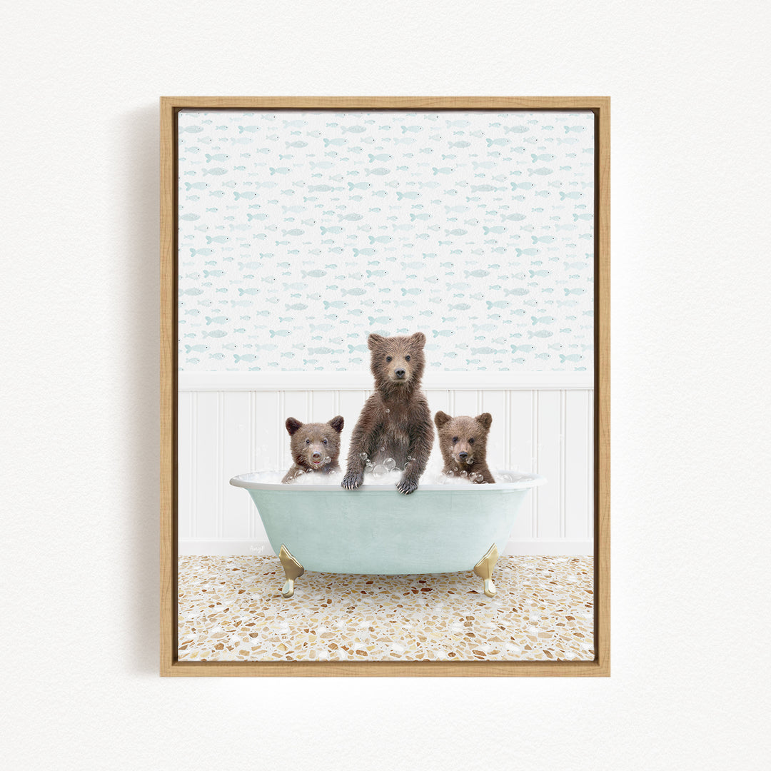 A framed image depicting three bears sitting in a bathtub, with one bear standing and the other two sitting.