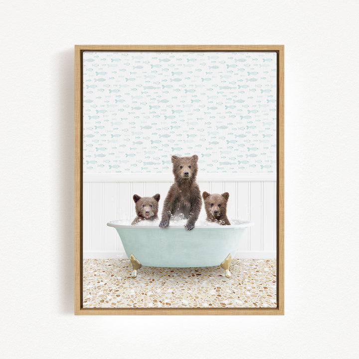 A framed image depicting three bears sitting in a bathtub, with one bear standing and the other two sitting.