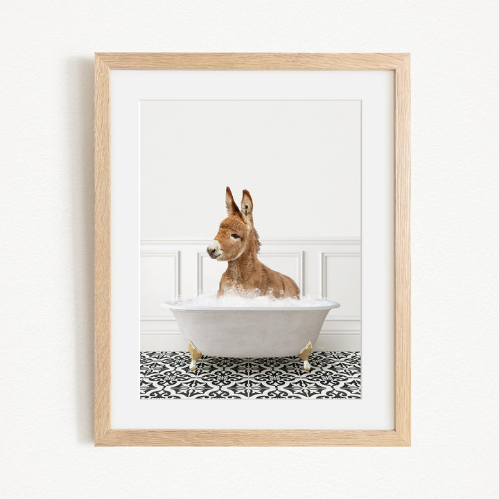 A donkey is sitting in a white bathtub filled with bubbles, creating a whimsical and playful scene.