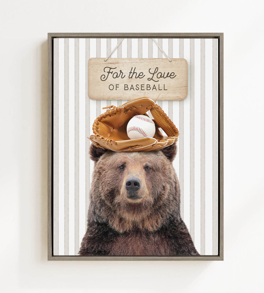A framed image of a brown bear wearing a baseball glove and ball on its head, with a wooden sign above that says "For the Love of Baseball".