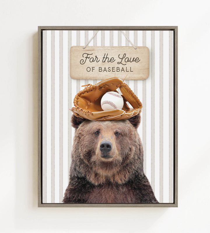 A framed image of a brown bear wearing a baseball glove and ball on its head, with a wooden sign above that says "For the Love of Baseball".
