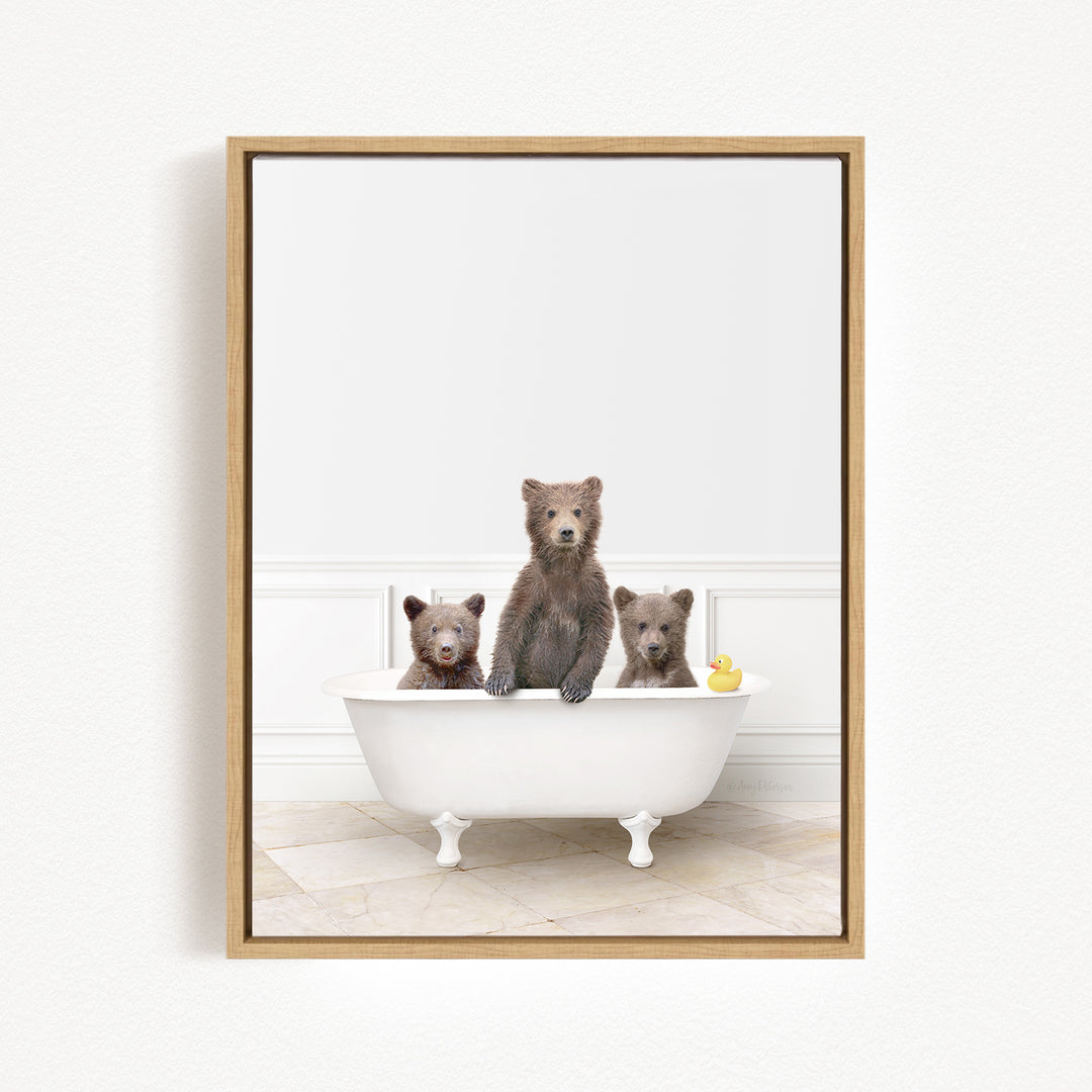 Three brown bears sitting in a white bathtub, with one bear holding a yellow rubber duck.