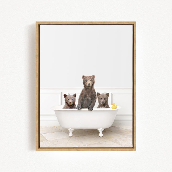Three brown bears sitting in a white bathtub, with one bear holding a yellow rubber duck.