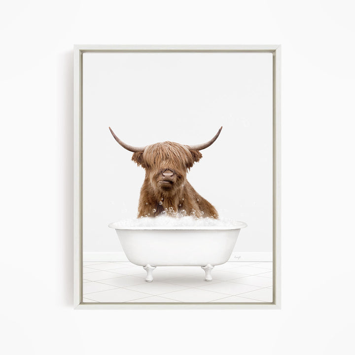 A brown cow with long horns is sitting in a white bathtub filled with water, appearing to enjoy the bath.