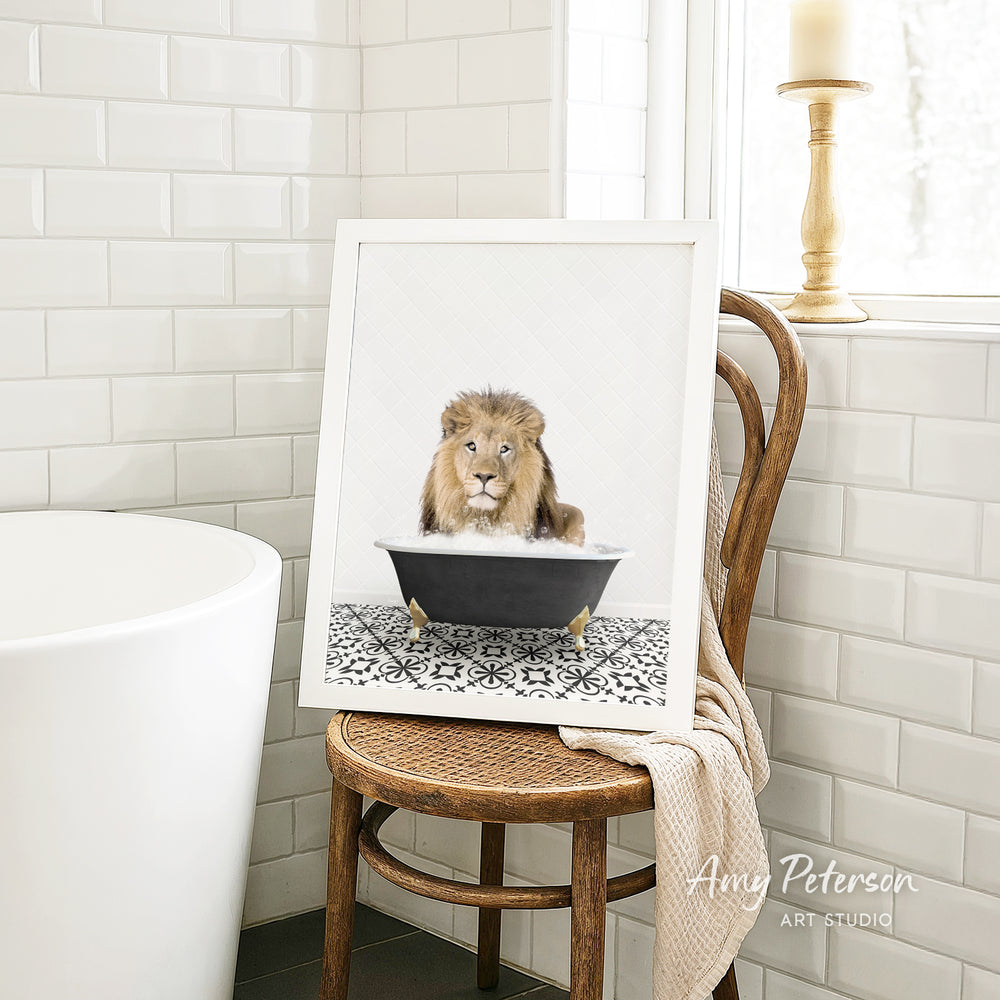 A framed image of a lion sitting in a bathtub, surrounded by a patterned tile floor, is displayed on a wooden chair in a bathroom setting.
