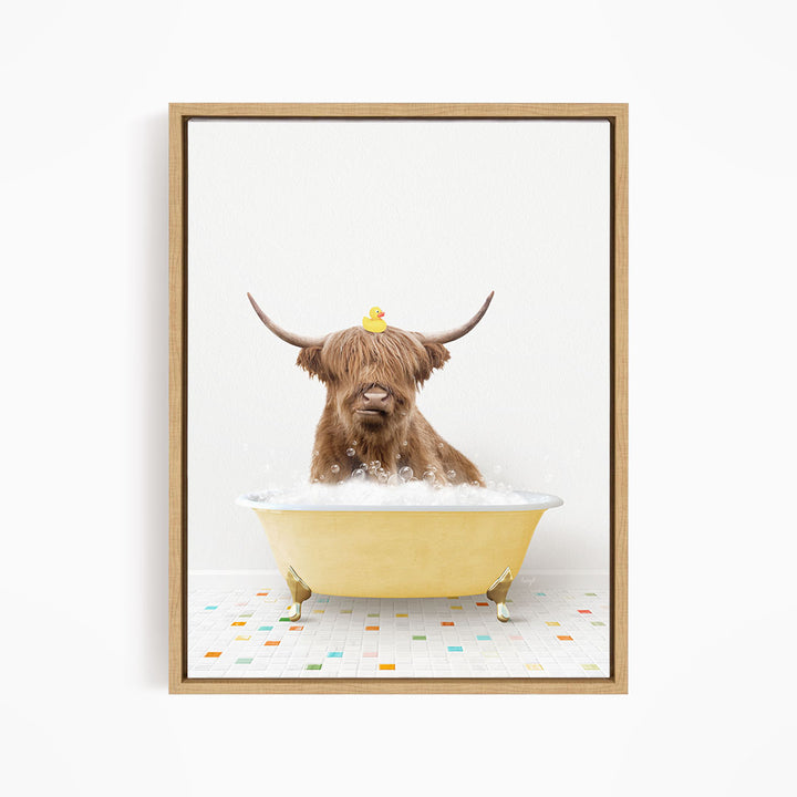 A brown cow with long horns is sitting in a yellow bathtub filled with bubbles, with a rubber duck perched on its head.