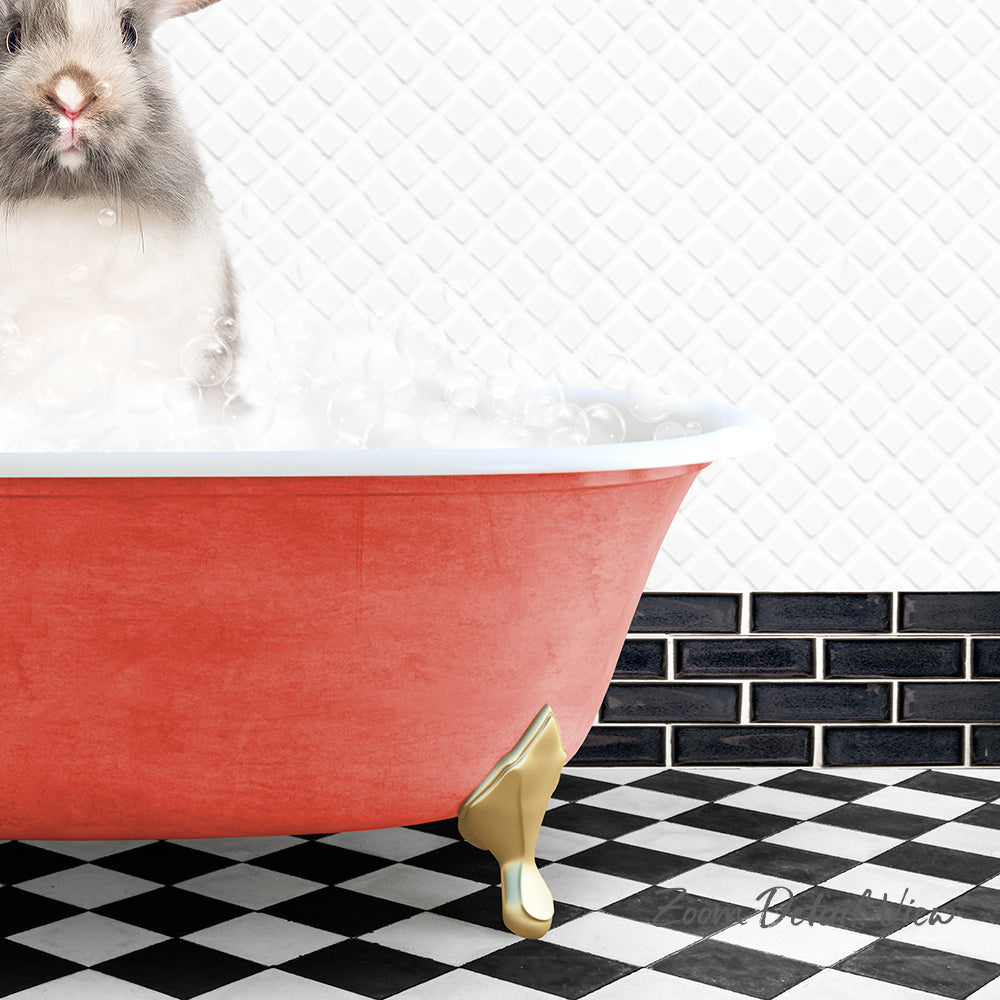 A small, fluffy rabbit is sitting in a red bathtub filled with bubbles, with a black and white checkered floor in the background.