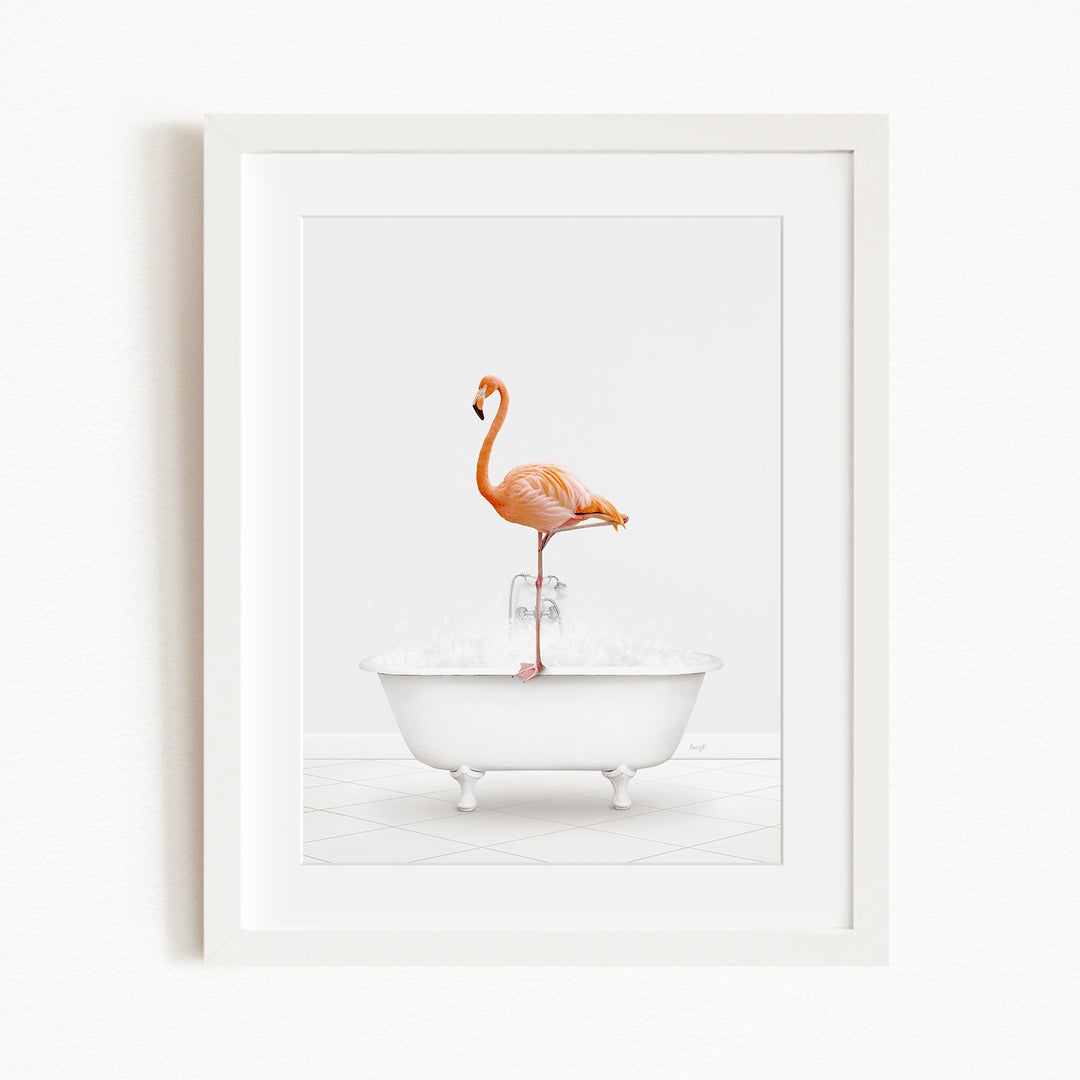 A framed image of a flamingo standing on the edge of a white bathtub filled with water.