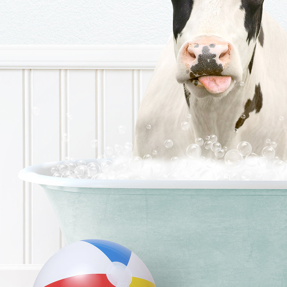 a cow in a bathtub with bubbles and a beach ball