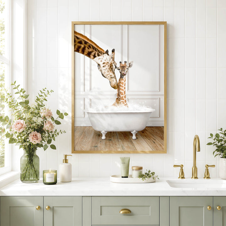A framed image of two giraffes standing in a bathtub, with one giraffe reaching over the other, is displayed on a white wall above a bathroom counter with various toiletries and a vase of flowers.