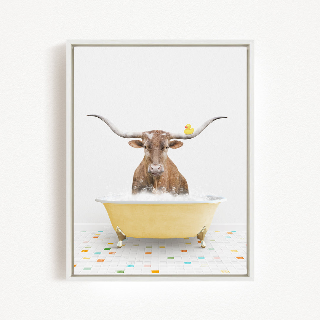A brown cow with long horns is sitting in a yellow bathtub filled with bubbles, with a rubber duck floating on the water.