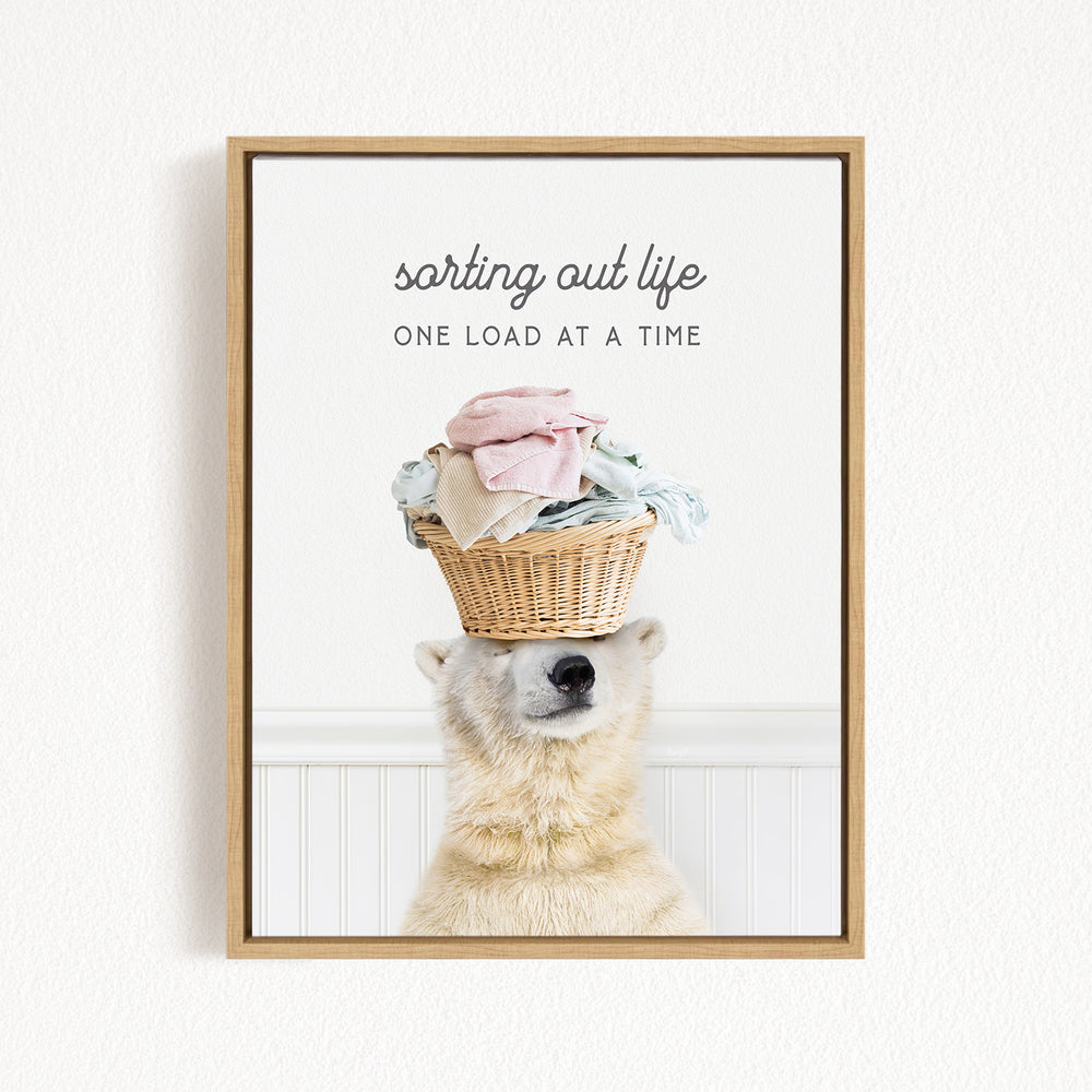 A polar bear balancing a basket of laundry on its head, with the text "sorting out life" above the basket.