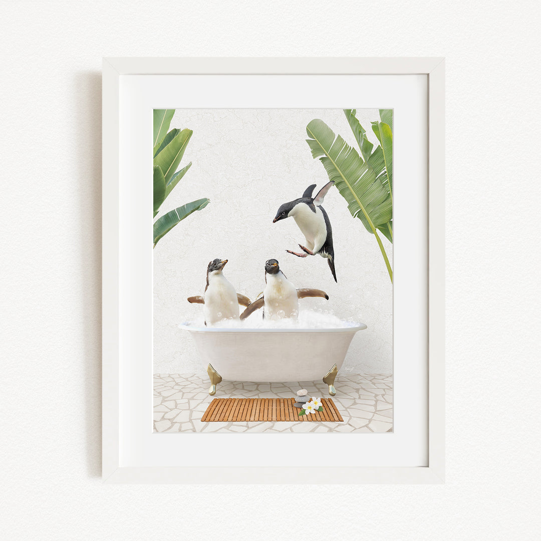 A framed image depicting three penguins sitting in a bathtub, surrounded by tropical plants and flowers.