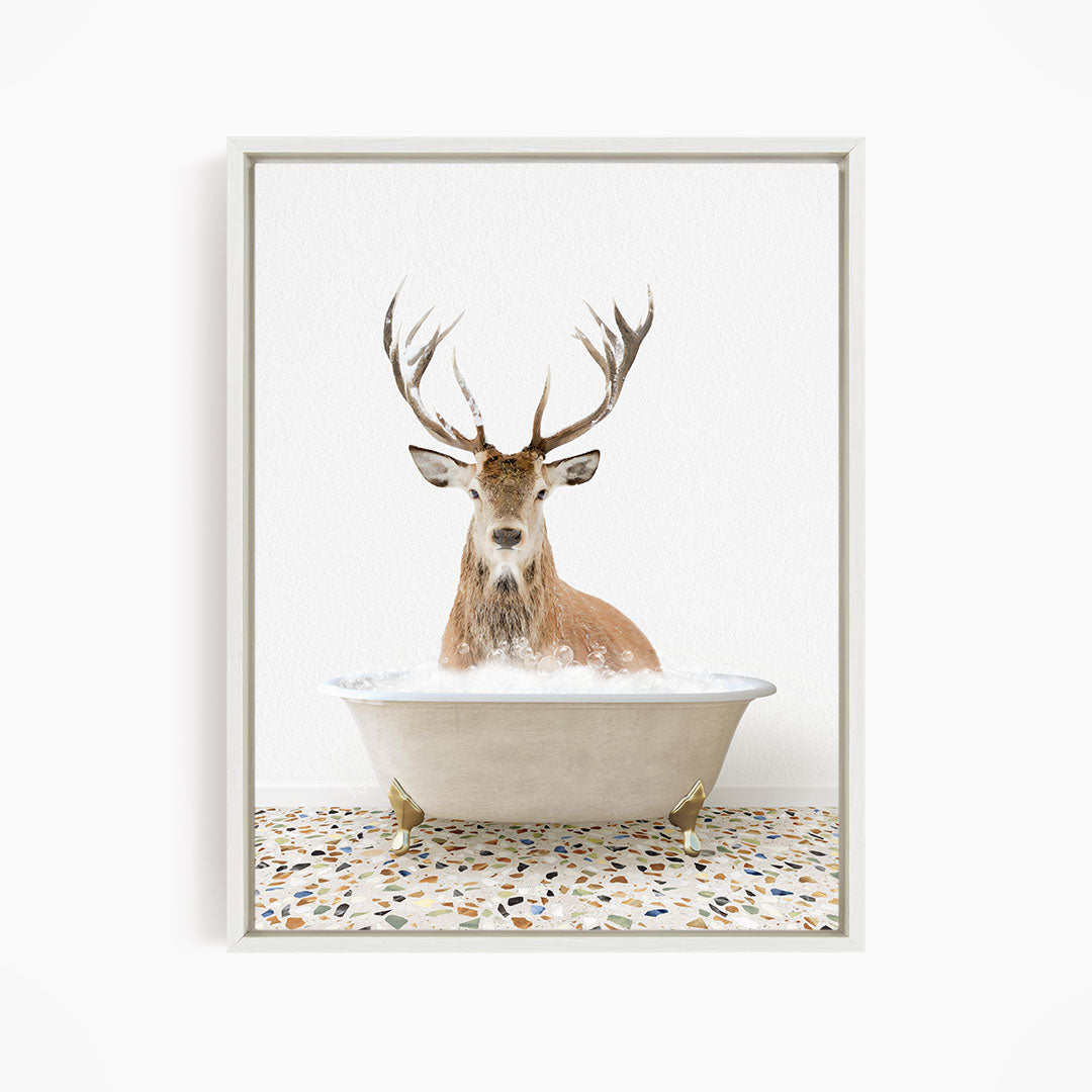 A deer with large antlers is sitting in a bathtub filled with water, creating a whimsical and unexpected scene.