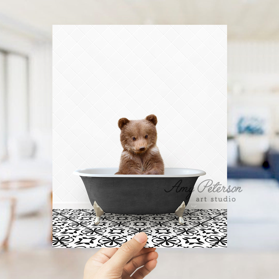 a person holding up a picture of a bear in a bathtub