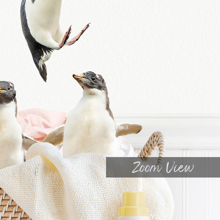 A group of penguins standing in a basket, with one penguin in mid-jump.