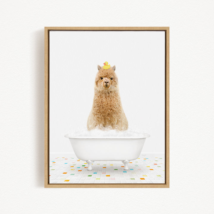 A fluffy brown llama sits in a white bathtub filled with bubbles, with a yellow rubber duck perched on its head.