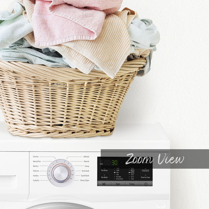 A wicker laundry basket filled with folded clothes sits atop a white washing machine with a digital display.