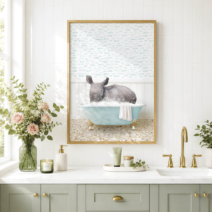A framed image of a rhinoceros sitting in a bathtub, surrounded by a floral arrangement and various bathroom accessories, such as a candle, soap dispenser, and a tray with a plant.