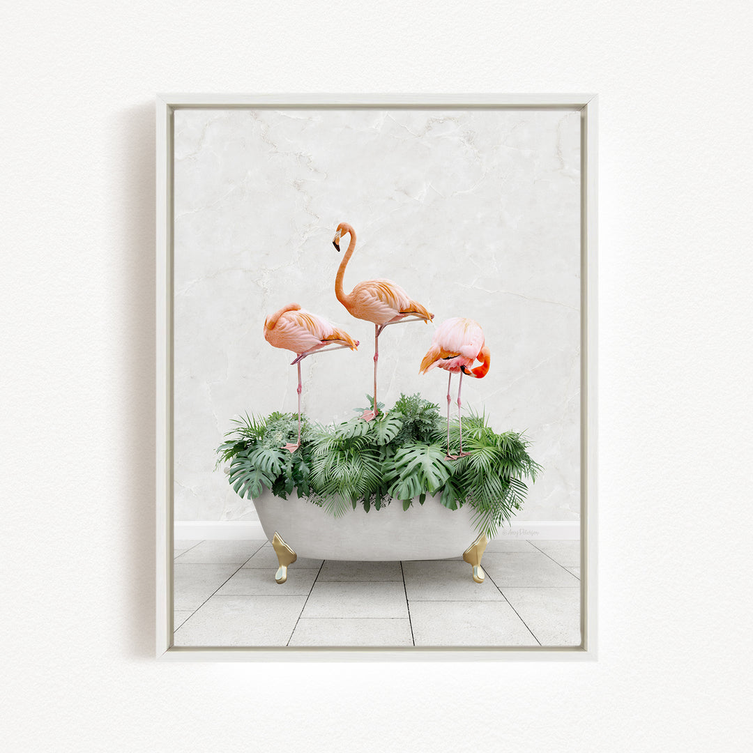 A framed image depicting three pink flamingos standing on a bathtub filled with green plants.
