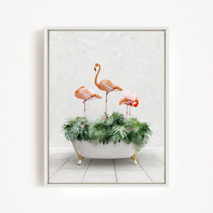 A framed image depicting three pink flamingos standing on a bathtub filled with green plants.