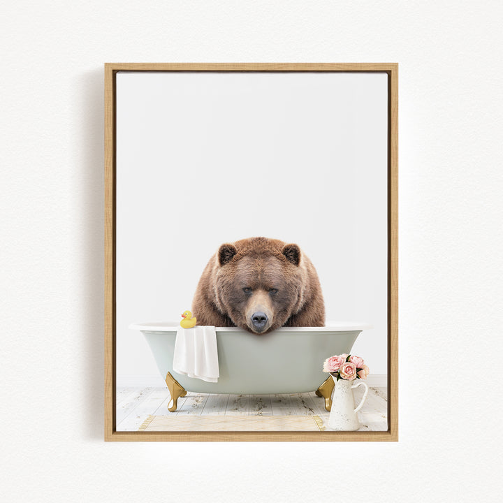 A brown bear is sitting in a bathtub filled with water, surrounded by a yellow rubber duck and pink flowers.
