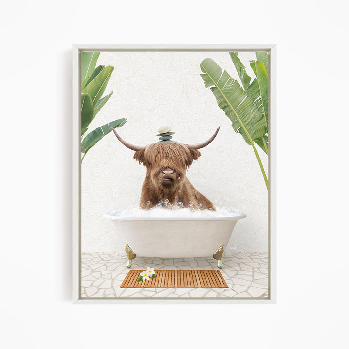 A brown cow with horns is sitting in a white bathtub filled with bubbles, surrounded by tropical plants and a wooden mat on the floor.