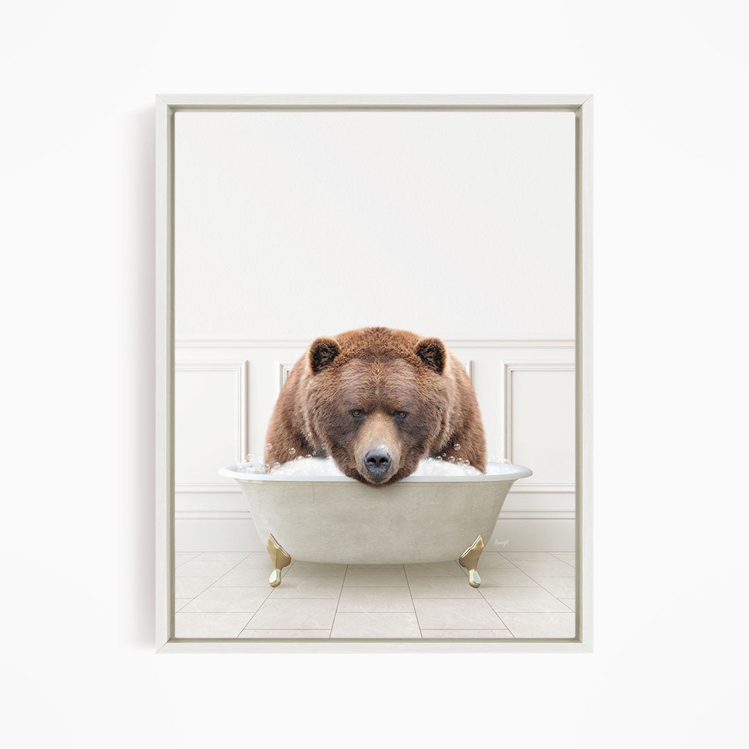 A brown bear is sitting in a white bathtub filled with water, appearing to be enjoying a relaxing bath.