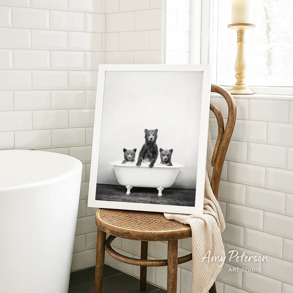 A framed black and white photograph of three bears sitting in a bathtub, with one bear sitting in the center and the other two bears sitting on either side.
