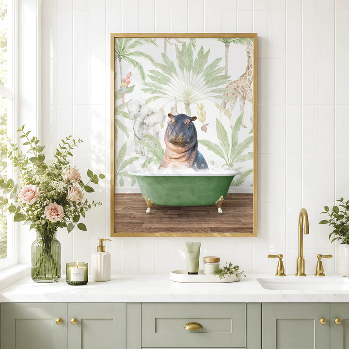 A framed image of a hippopotamus sitting in a green bathtub, surrounded by tropical foliage, is displayed on a white tiled wall above a bathroom vanity with a sink and gold faucets.