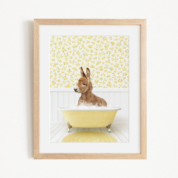A donkey is sitting in a yellow bathtub filled with water, surrounded by a yellow floral pattern on the wall behind it.