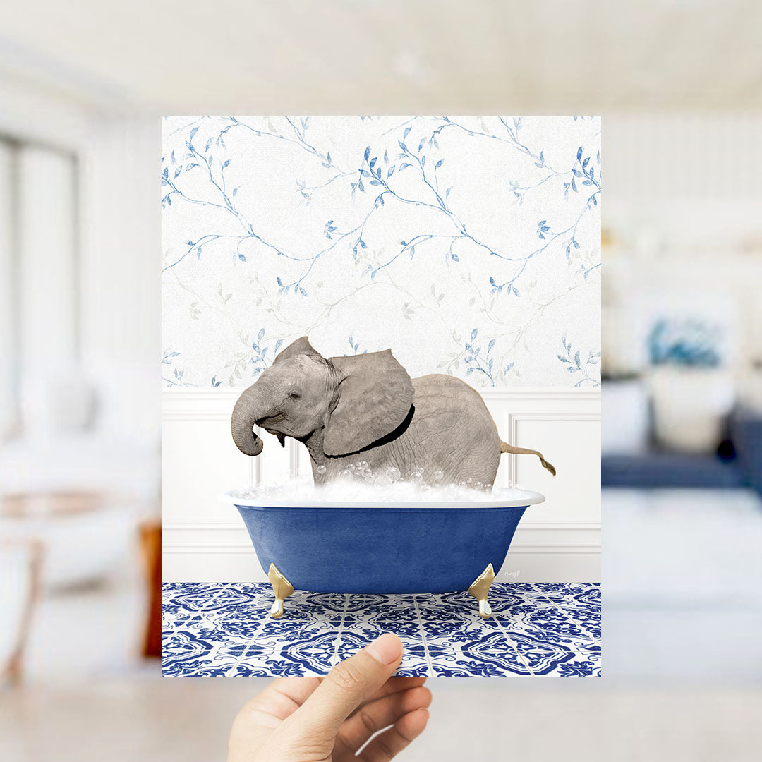 A gray elephant is sitting in a blue bathtub filled with water, surrounded by a blue and white patterned floor.