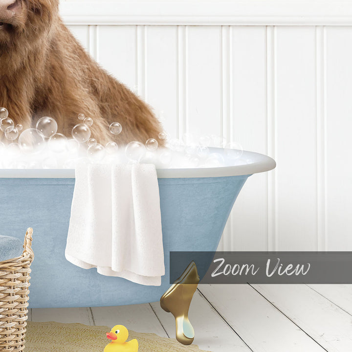 A brown dog is sitting in a blue bathtub filled with bubbles, surrounded by a yellow rubber duck and a white towel.