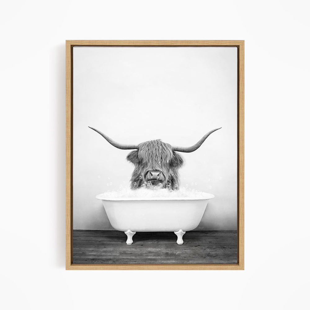 A black and white image of a horned animal, possibly a yak or a yakdog, sitting in a white bathtub and enjoying a bath.