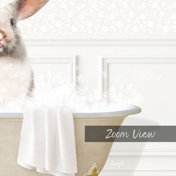 A white rabbit sitting in a bathtub filled with bubbles, with a towel draped over the side of the tub.