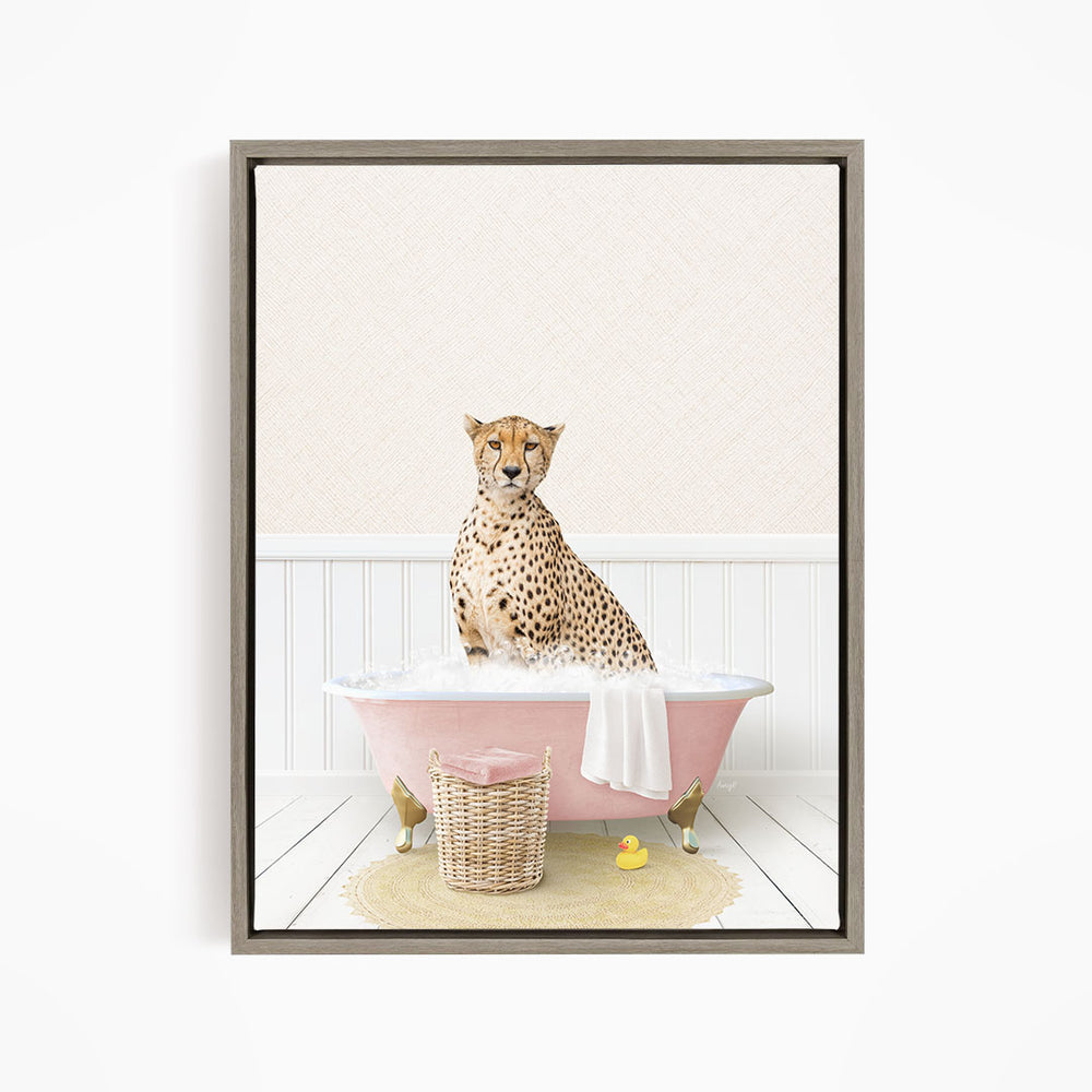 A cheetah sitting in a pink bathtub filled with bubbles, surrounded by a yellow rubber duck and a basket.