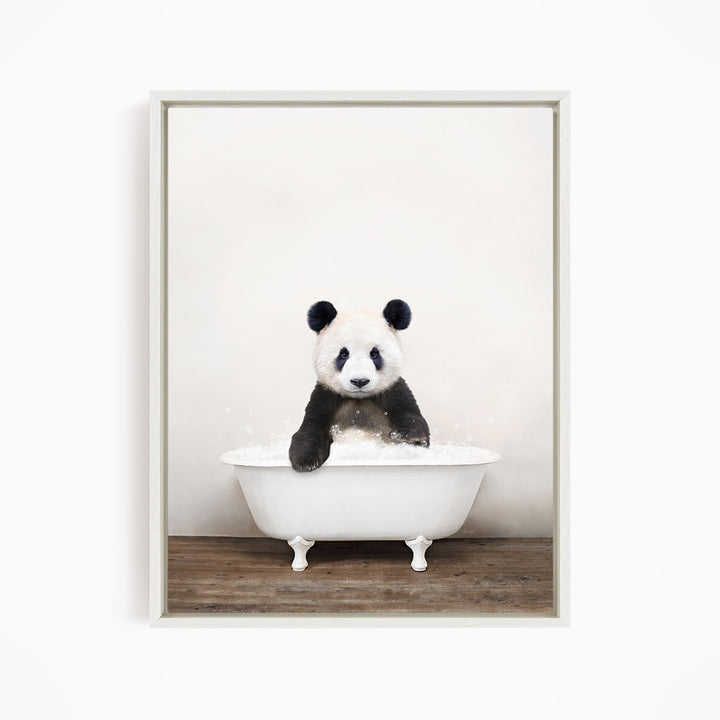 A panda bear sitting in a white bathtub filled with bubbles, looking directly at the camera.
