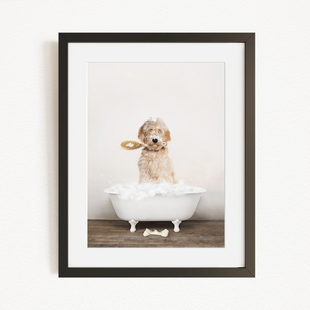 A dog sitting in a white bathtub, holding a toothbrush in its mouth, with a bone on the floor.