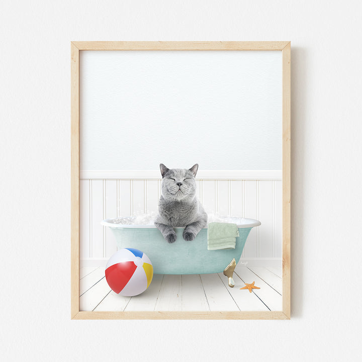 a cat sitting in a bathtub with a beach ball