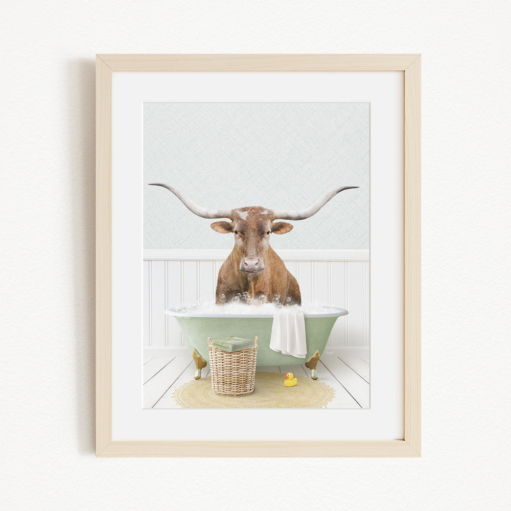 A brown cow with large horns is sitting in a green bathtub filled with water, surrounded by a yellow rubber duck and a basket.