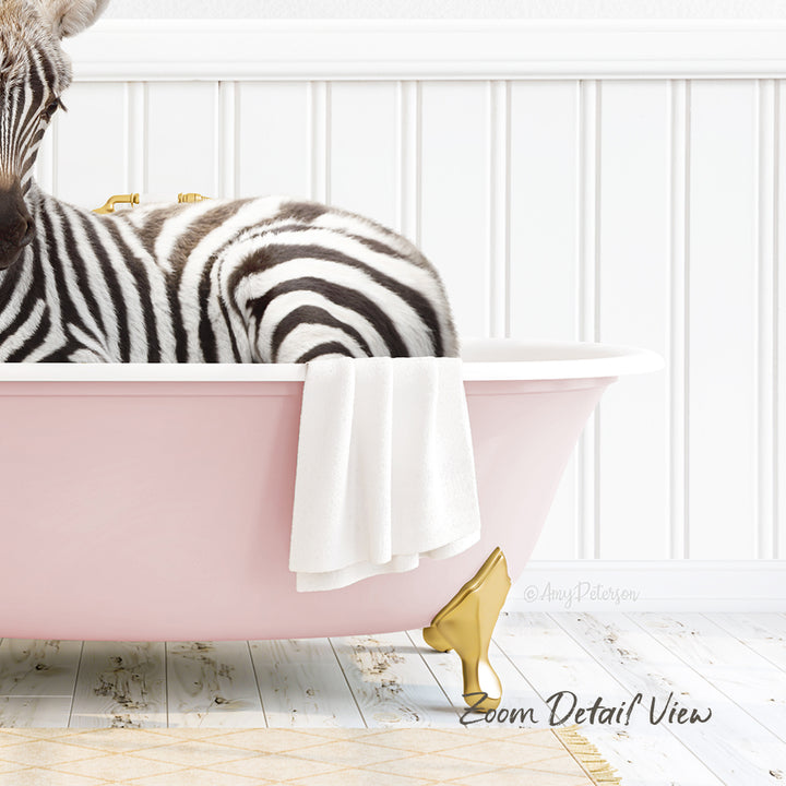 A zebra is sitting in a pink bathtub, with a towel hanging on the side and a gold-colored bathtub faucet.