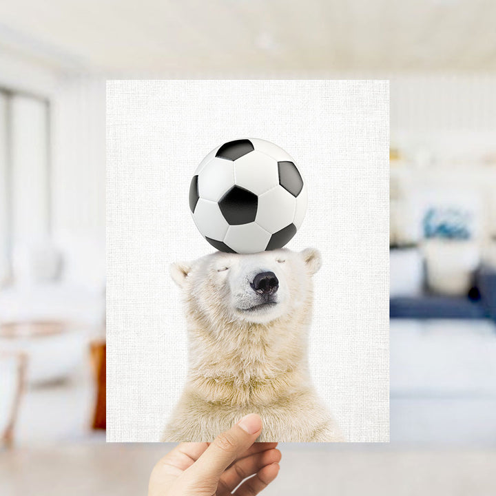 A polar bear balancing a soccer ball on its head.