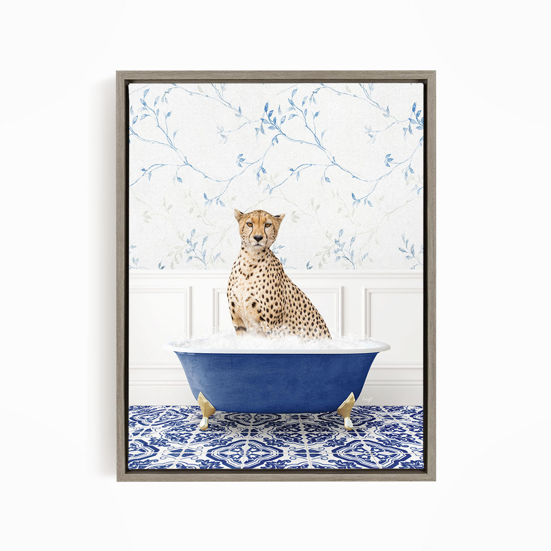 A cheetah sitting in a blue bathtub filled with water, with a patterned tile floor and a floral wallpaper in the background.
