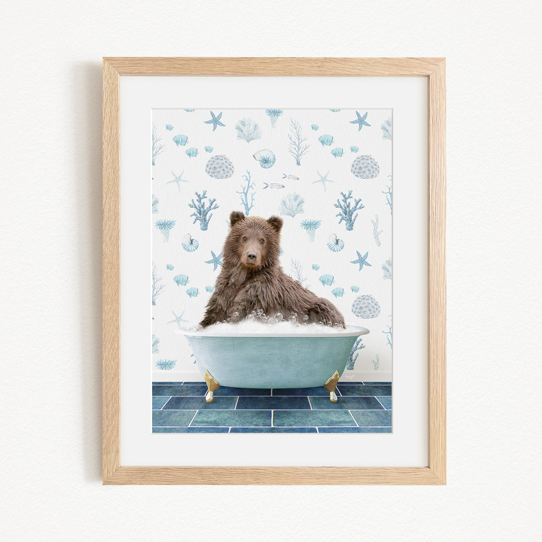 A brown bear sitting in a blue bathtub filled with bubbles, surrounded by a pattern of seashells and starfish.