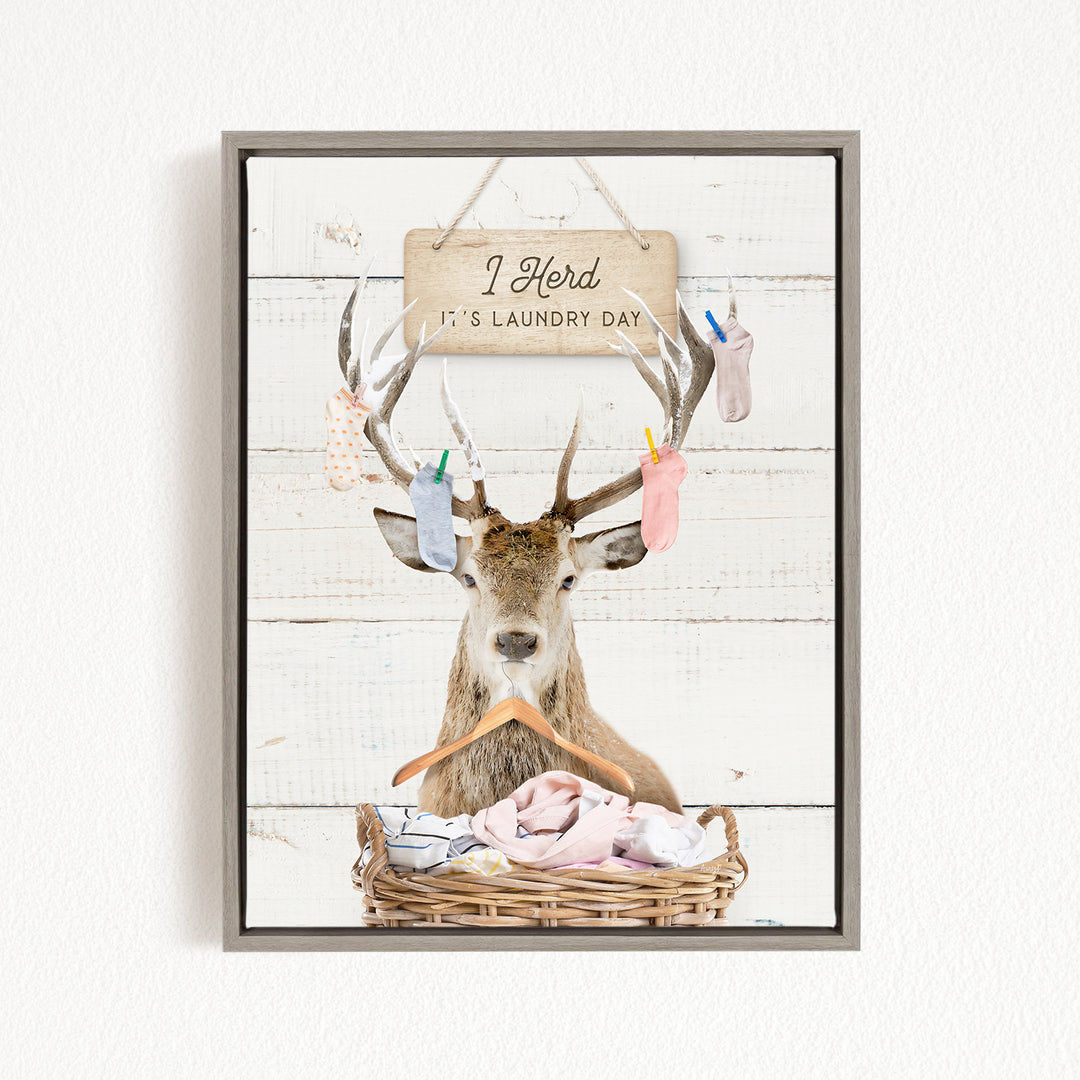 A deer with antlers is sitting in a wicker basket, with a sign above it that says "I herd it's laundry day".