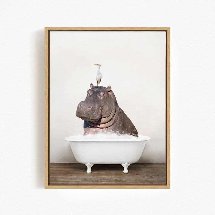 A large, brown hippopotamus is sitting in a white bathtub, with a white bird perched on its head.